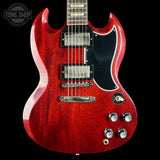 Red electric guitar with a black pickguard on a black background, featuring the 'Tone Shop' logo.