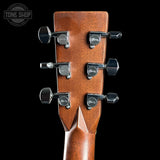 Close-up of a guitar headstock with tuning pegs on a black background, featuring the Tone Shop logo.