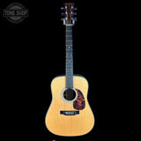 Acoustic guitar with a visible brand logo on a black background