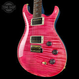 Pink electric guitar with a 'Tone Shop' logo in the corner