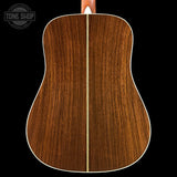 Back of a wooden acoustic guitar with 'Tone Shop' logo in the corner.