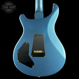 Blue electric guitar with a close-up of the back and bridge on a black background, featuring 'Tone Shop' branding.