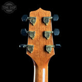 Close-up of a guitar headstock with tuning pegs on a black background, featuring the Tone Shop logo.