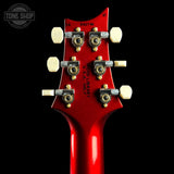 Close-up of a red guitar headstock with tuning pegs on a black background, featuring 'Tone Shop' branding.
