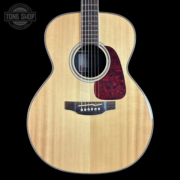 Acoustic guitar with a visible brand logo on a black background