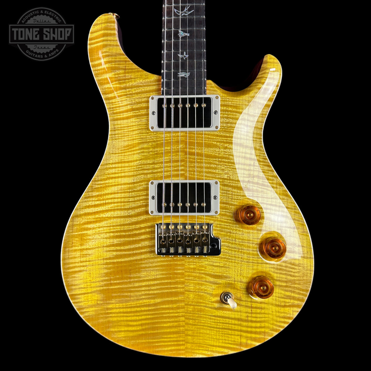 Electric guitar with a distinctive yellow finish on a black background, featuring the 'Tone Shop' logo.