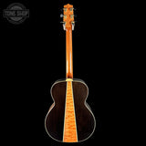 Back view of an acoustic guitar with a visible brand logo in the corner.