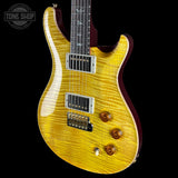 Yellow electric guitar with a dark finish on a black background, featuring the Tone Shop logo.