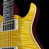 Close-up of a yellow electric guitar with a black background