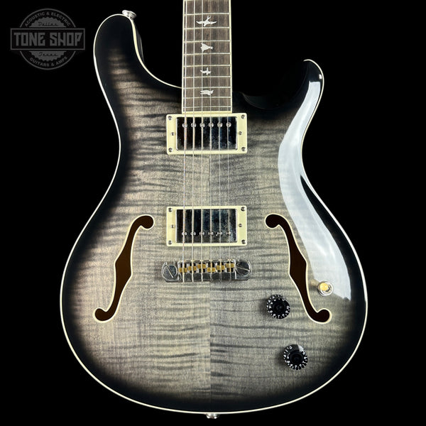 Electric guitar with a black and white pattern on a black background, featuring the Tone Shop logo.