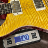 Yellow electric guitar on a digital scale displaying weight