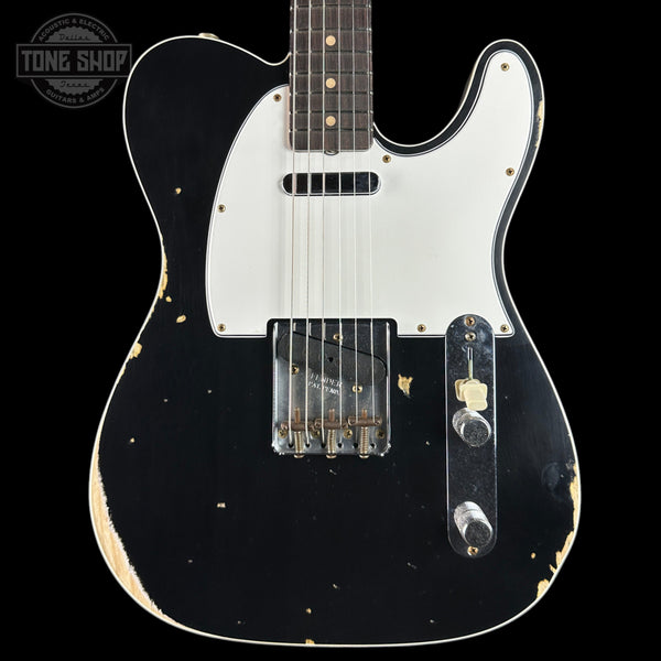 Black electric guitar with white pickguard on a black background, featuring 'Tone Shop' logo.