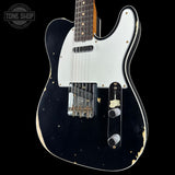 Black electric guitar with white pickguard on a black background, featuring 'Tone Shop' logo.