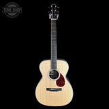 Acoustic guitar with a visible brand logo on a black background