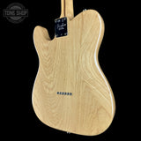 The back of a Fender Telecaster electric guitar in a natural wood finish, shown against a solid black background with a Tone Shop watermark in the top left corner.