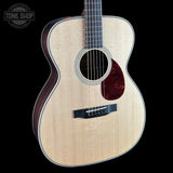 Acoustic guitar with a visible brand logo on a black background