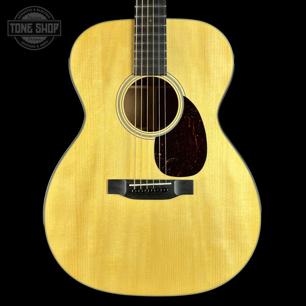Acoustic guitar with a visible brand logo on a black background