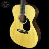 Acoustic guitar with a visible brand logo on a black background