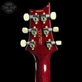 Close-up of a red guitar headstock with tuning pegs on a black background, featuring 'Tone Shop' branding.