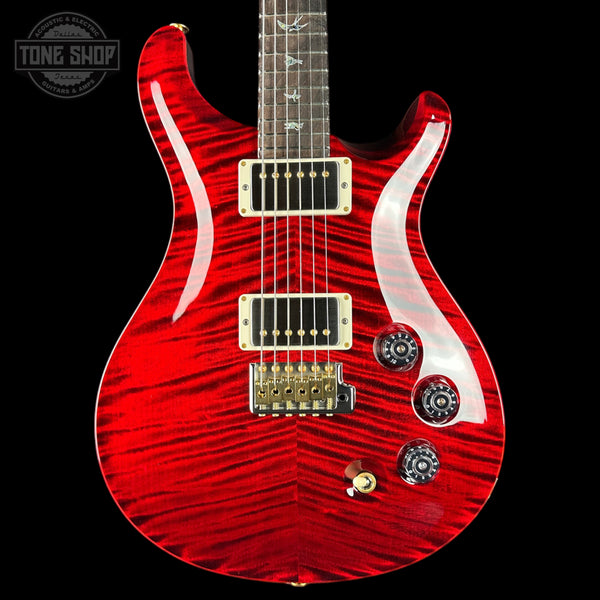 Red electric guitar with a wavy pattern on a black background, featuring the Tone Shop logo.