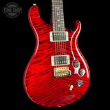 Red electric guitar with a black background, featuring the Tone Shop logo.