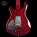 Red electric guitar body with visible brand logo on a black background