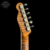 Close-up of the headstock of an electric guitar with a flamed maple wood finish and six silver tuning pegs, shown against a solid black background.