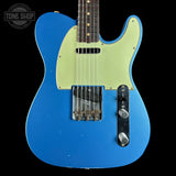 A blue electric guitar with a pale yellow-green pickguard, shown against a black background. A Tone Shop watermark is visible in the top left corner.