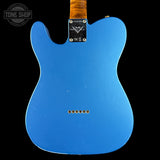 The back of a blue Fender Telecaster electric guitar, featuring a black Fender logo plate and gold-toned hardware, shown against a solid black background.