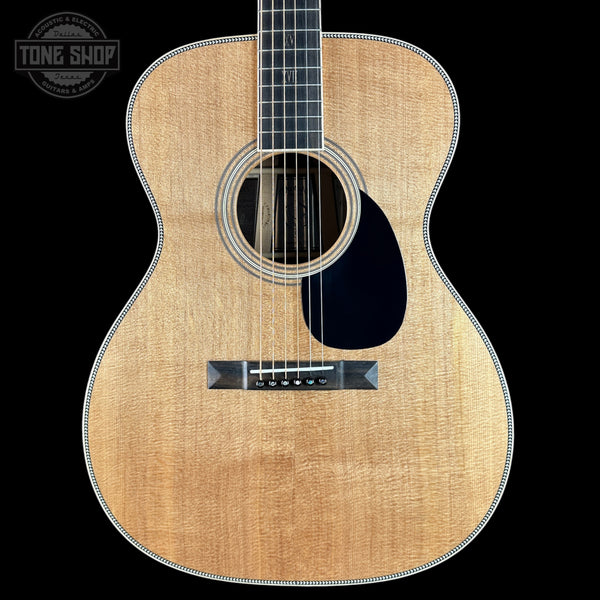 Acoustic guitar with a visible brand logo on a black background