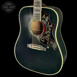 Acoustic guitar with decorative inlay on a black background, featuring the Tone Shop logo.