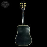 Back view of a black acoustic guitar with a 'Tone Shop' logo in the corner.
