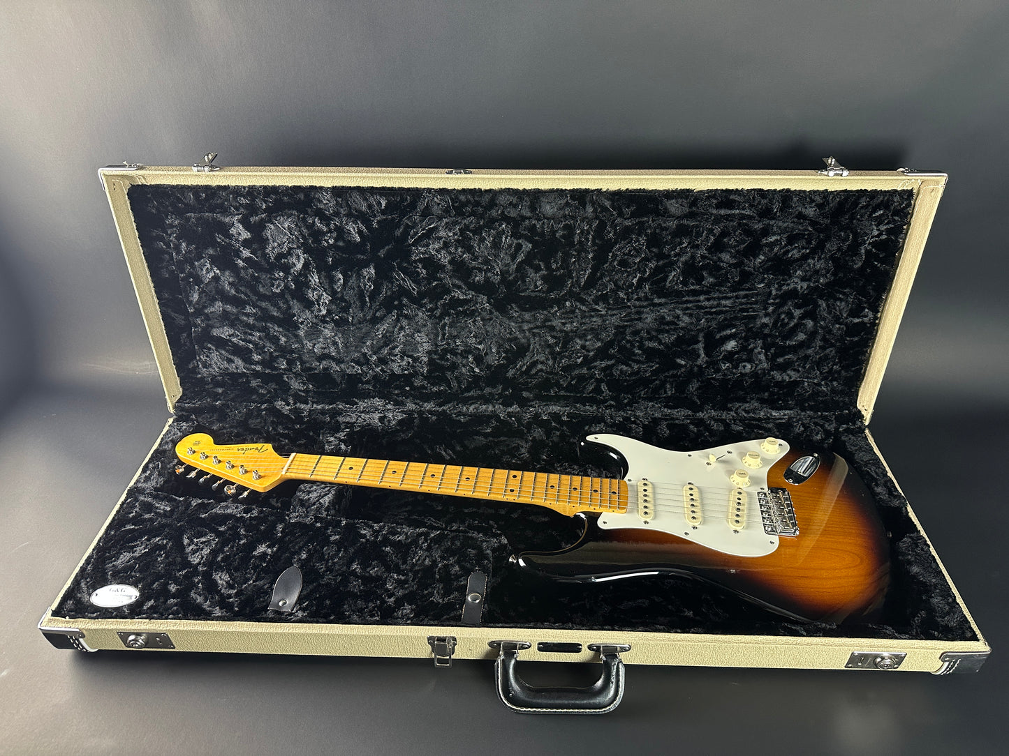Fender Stratocaster guitar in a case on a gray background