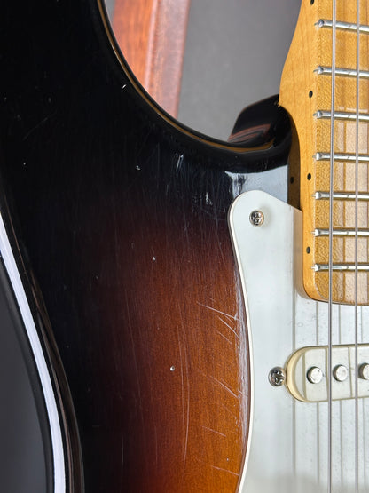 Close-up of a guitar's neck and body with visible wear.