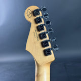 Guitar headstock with tuning pegs on a dark background
