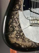 Close-up of a guitar with paisley patterned body