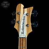 Close-up of a Rickenbacker guitar headstock with brand name on a black background