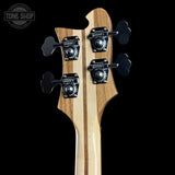 Close-up of a guitar headstock with tuning pegs on a black background, featuring the Tone Shop logo.