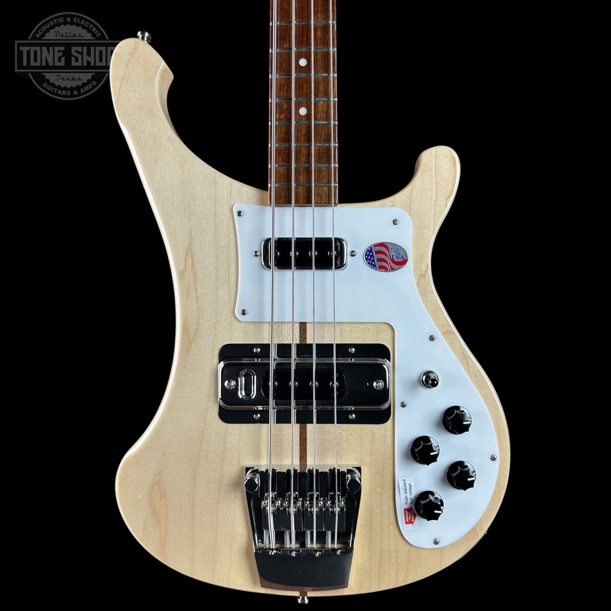 Bass guitar with a white pickguard and visible branding on a black background