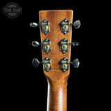 Close-up of a guitar headstock with tuning pegs on a black background, featuring the Tone Shop logo.