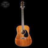 Acoustic guitar with a visible brand logo on a black background