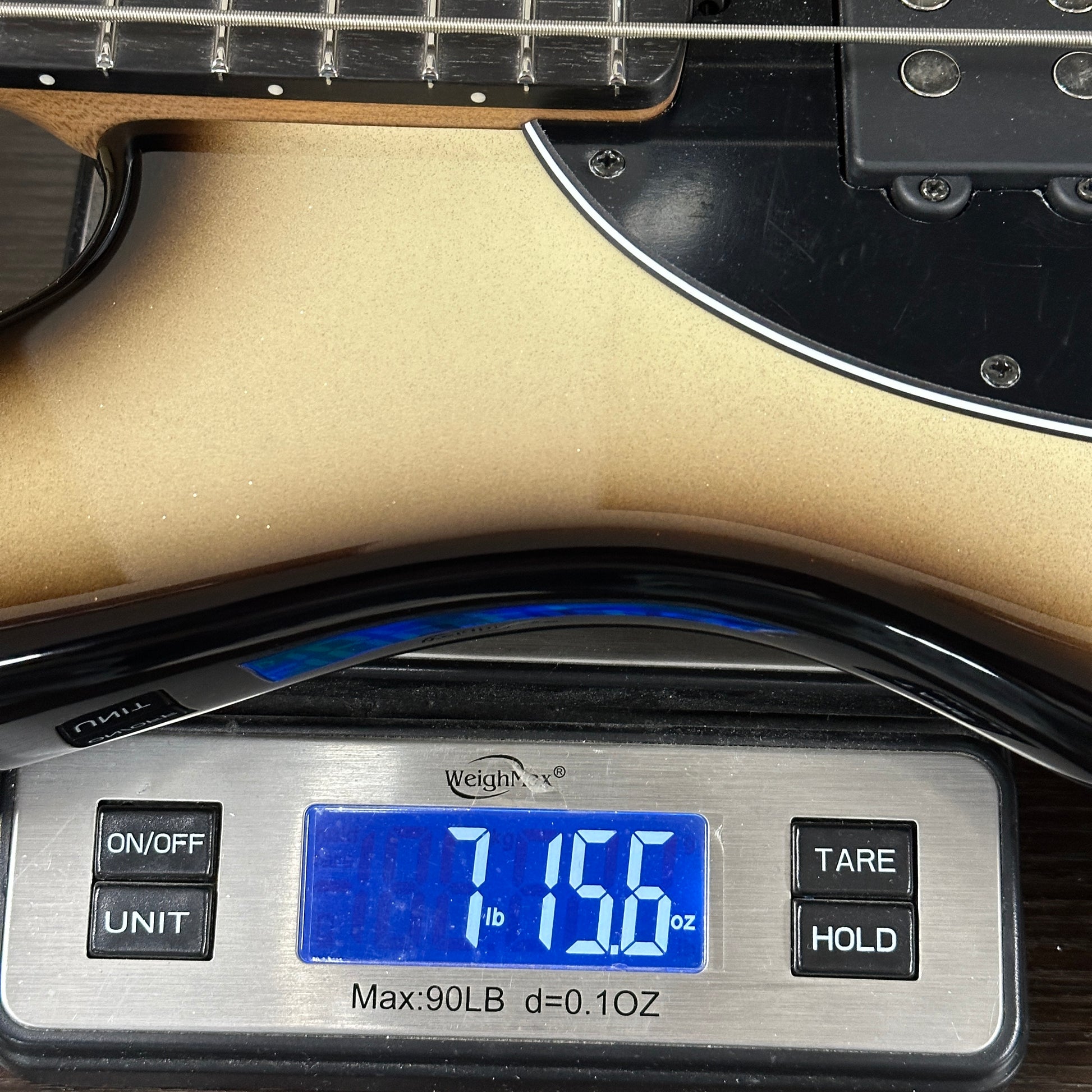 Digital scale displaying weight of a guitar, with a focus on the measurement.