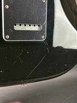 Close-up of a guitar's back plate with visible wear and tear.