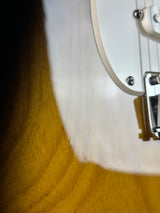 Close-up of a guitar's soundhole and headstock on a wooden surface