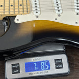 Electric guitar on a digital scale displaying weight