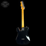 Black electric guitar with a blonde neck on a black background, featuring the Tone Shop logo.