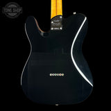Black electric guitar with a visible brand label on a black background