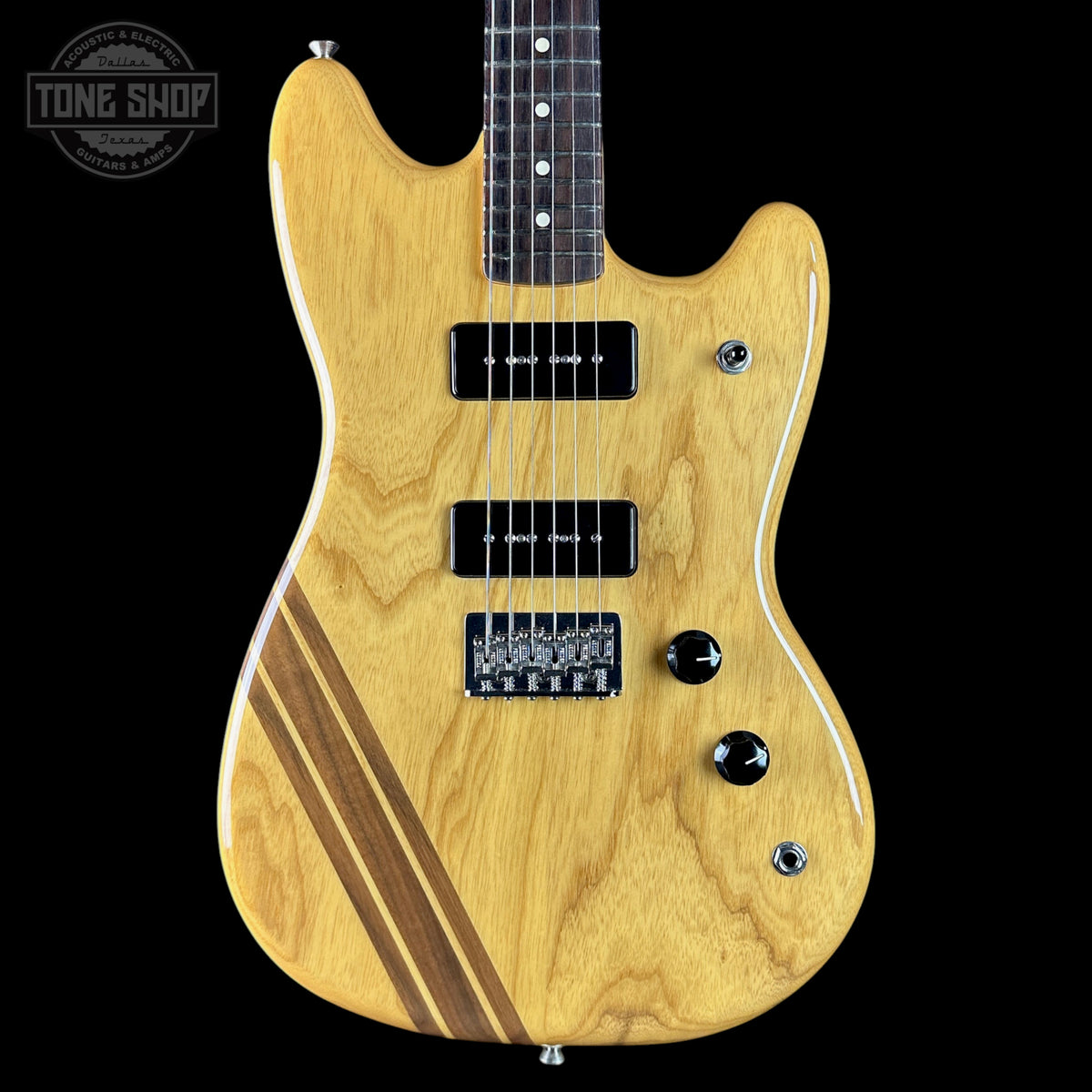 Wooden electric guitar with a black background, featuring the Tone Shop logo.