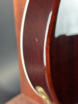 Close-up of a wooden surface with a metallic rim and a small gold emblem.