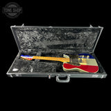 Colorful electric guitar in a black case with 'Tone Shop' logo.